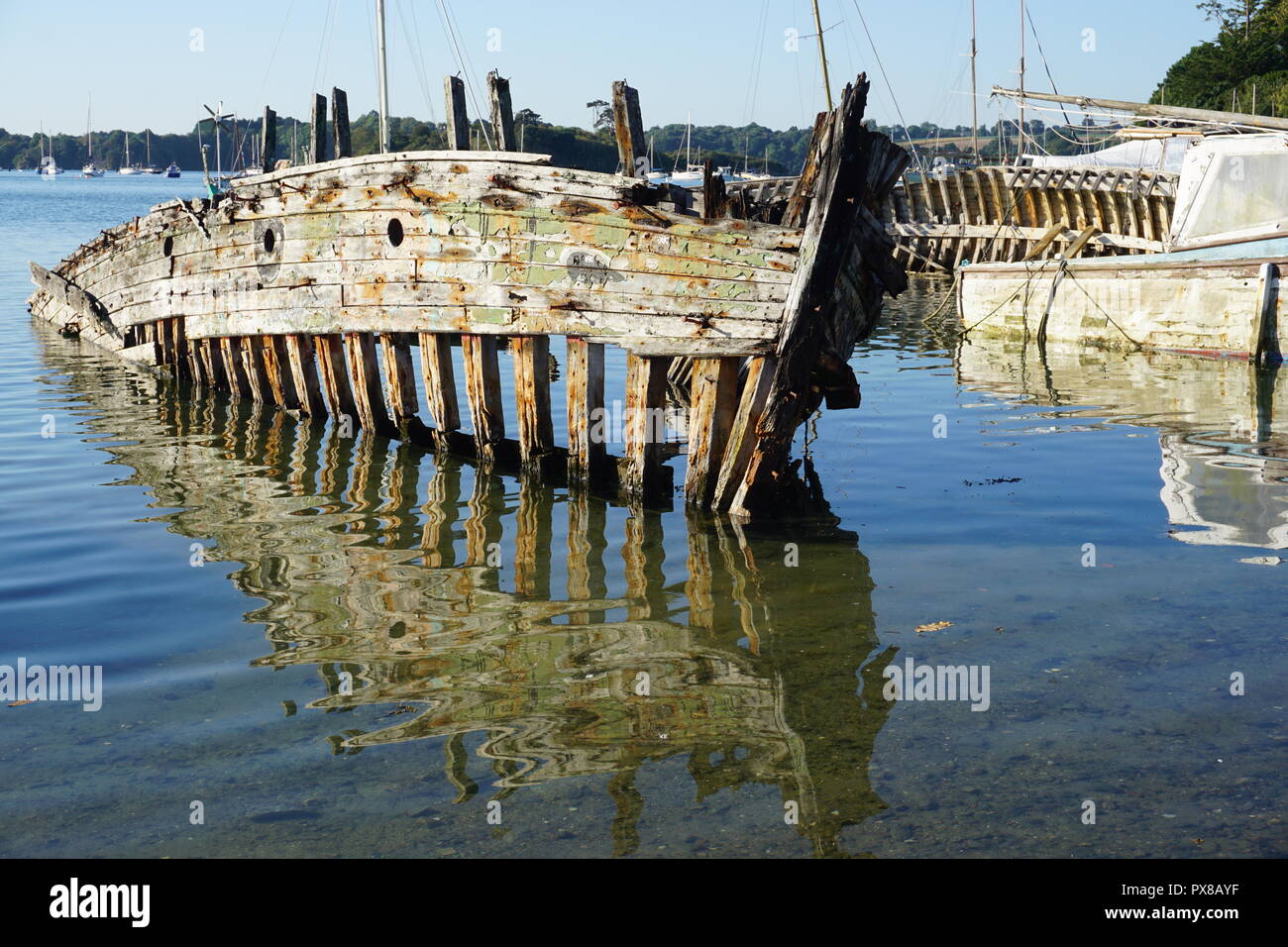Cimetière de bateaux le long de la côte en Bretagne, France sur une belle journée ensoleillée blue Banque D'Images