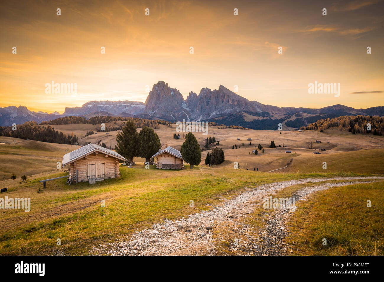 Belle vue sur la montagne chalets traditionnels en bois sur Scenic Alpe di Siusi célèbre Langkofel avec des pics de montagne dans l'arrière-plan dans la matinée d'or Banque D'Images
