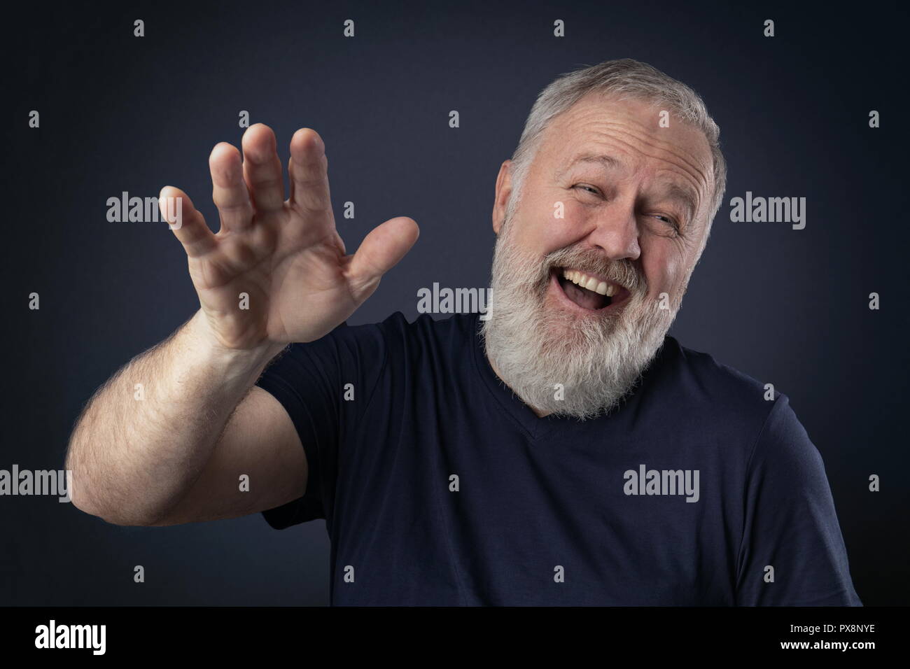 Vieil homme avec barbe grise rire avec sa paume vers le haut Banque D'Images