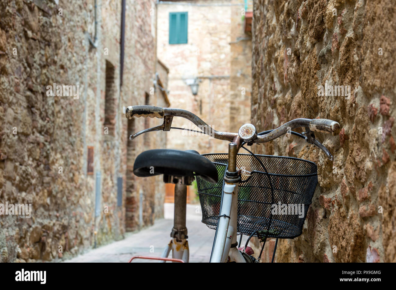 Vieux vélo rouge avec un peu de rouille dans alley d'un village médiéval Banque D'Images