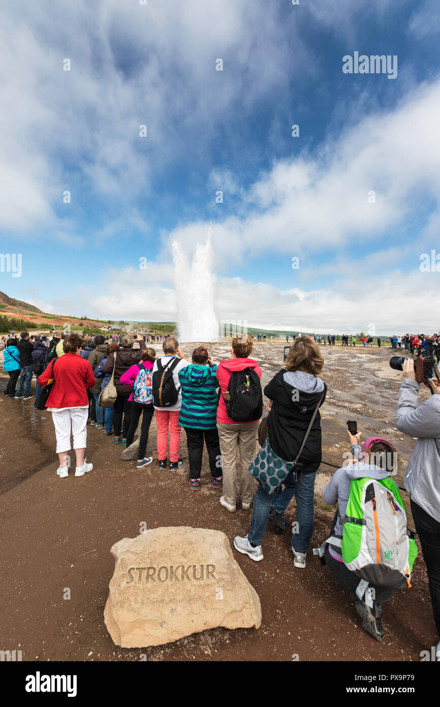 Les touristes regarder l'éruption du geyser Strokkur, la vallée de Haukadalur, rivière Hvítá, Islande. Banque D'Images