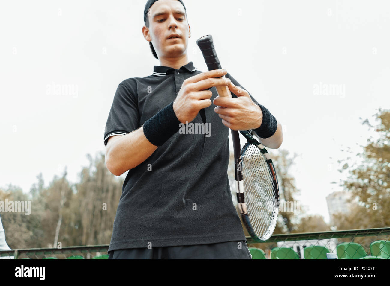 Man putting nouvelle bande de poignée de raquette de tennis. Ruban adhésif  d'emballage sur raquette Photo Stock - Alamy