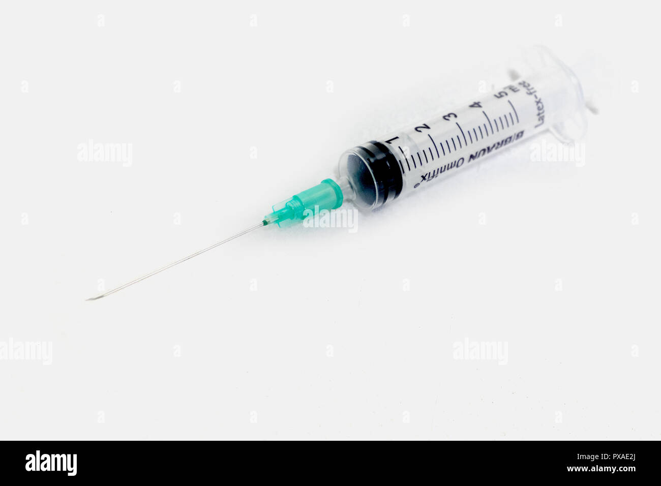 Une aiguille et une seringue sur un fond blanc Banque D'Images