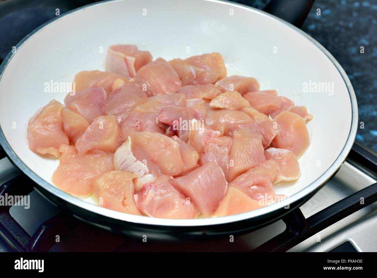 Couper les morceaux de poulet dans une casserole de cuisson Banque D'Images