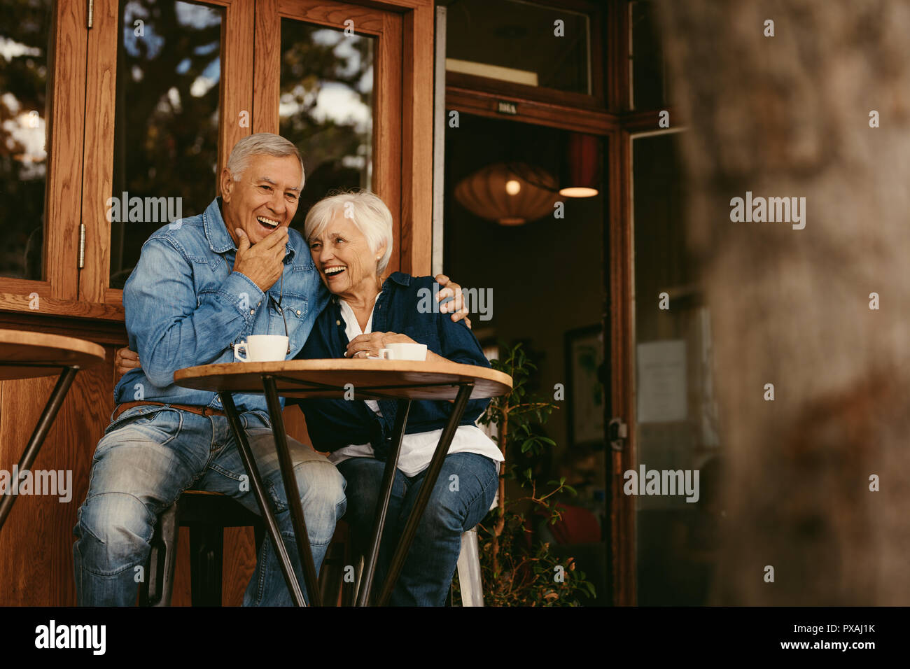 Senior couple in love sitting in cafe parler et avoir du plaisir. Bonne retraite couple relaxing at coffee shop. Banque D'Images