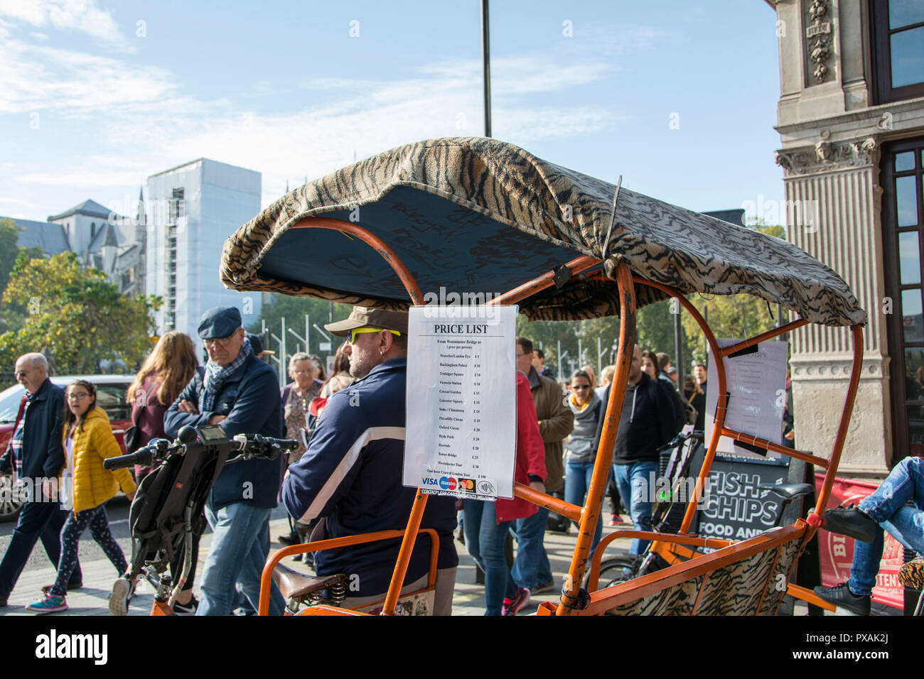 Les tarifs pour Londres rickshaw riders en attente d'embaucher à l'extérieur des maisons du Parlement, Londres, UK Banque D'Images