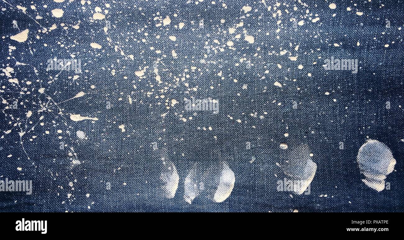 La texture d'un jean bleu denim ou arrière-plan. La texture de la peinture à l'huile abstraite sur toile. Gouttes de peinture colorés sur fond bleu denim, jeans. Banque D'Images