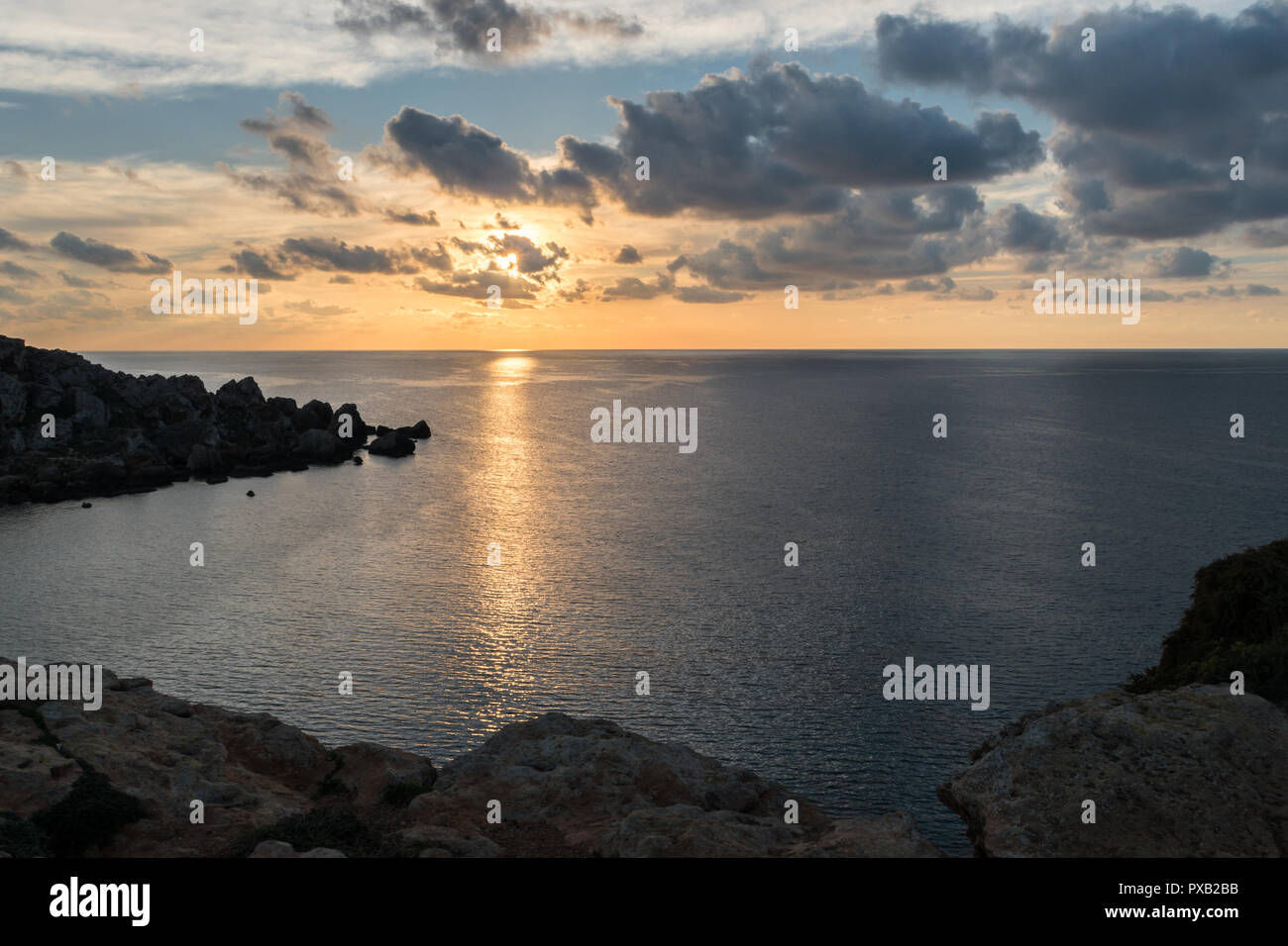 Mer calme paysage coucher du soleil à Malte au Golden bat. nuageux coucher de soleil sur la mer. soleil. réflexion vue paisible. la tranquillité. Banque D'Images