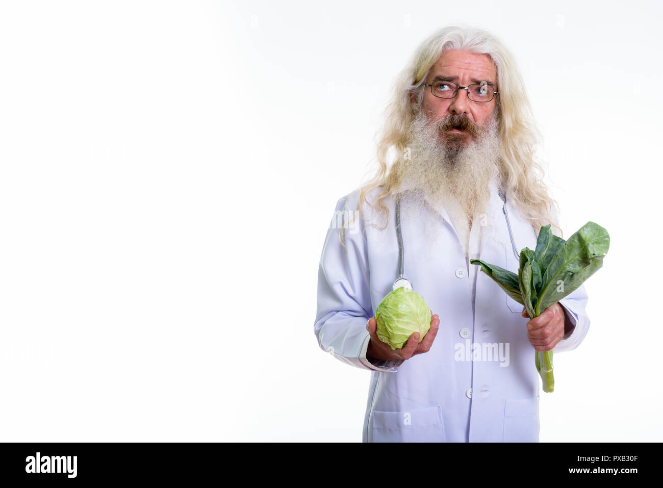 Studio shot of senior homme barbu médecin pense tout en maintenant Banque D'Images