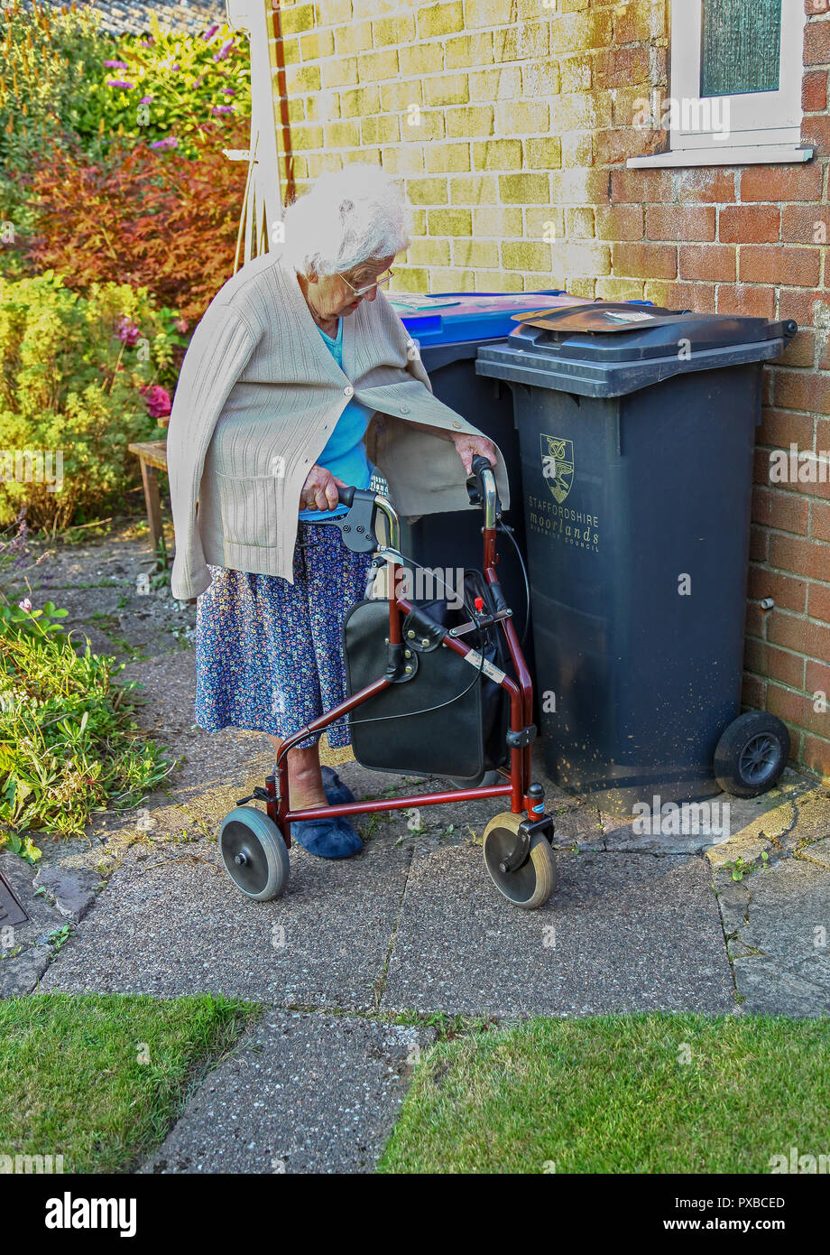 Une vieille femme marchant a l aide d un chariot a roues 3 poussette 3 roues aide a la marche ou 3 roues walker England UK Photo Stock Alamy