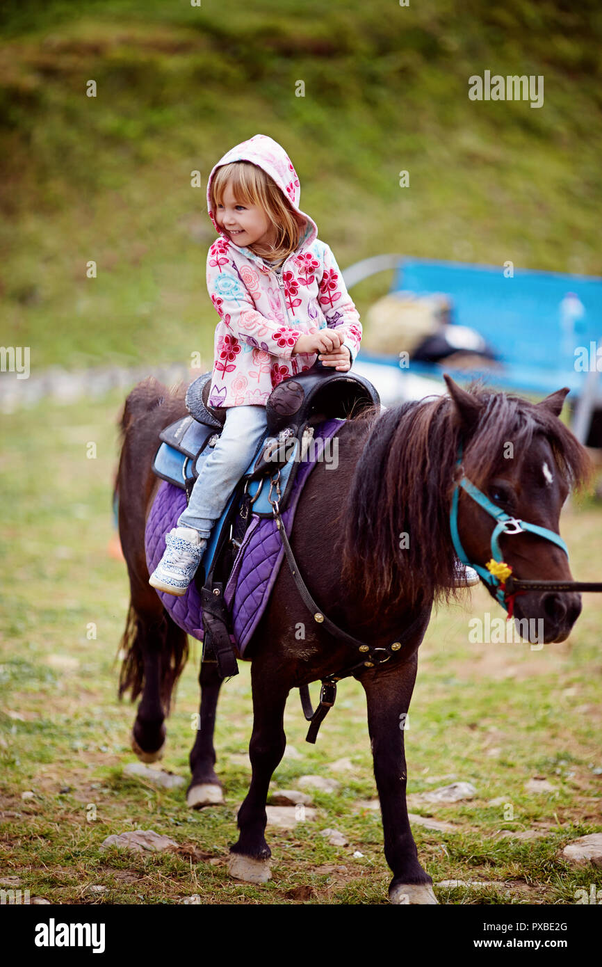 Petite fille équitation petit poney Banque D'Images