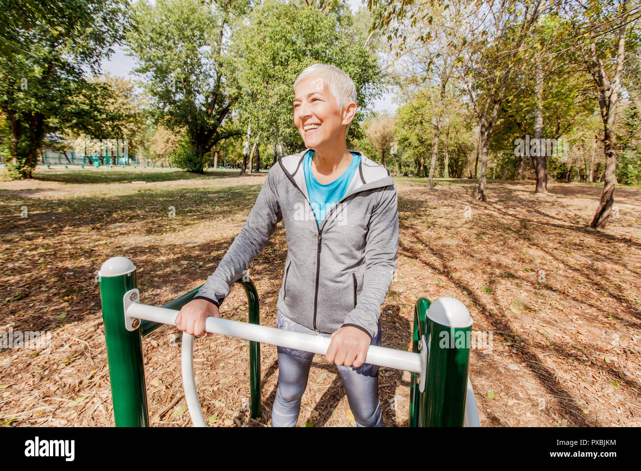 Vieille Femme dans l'exercice de sports de vêtements de plein air au parc de remise en forme, les modes de vie des personnes mûres. Banque D'Images