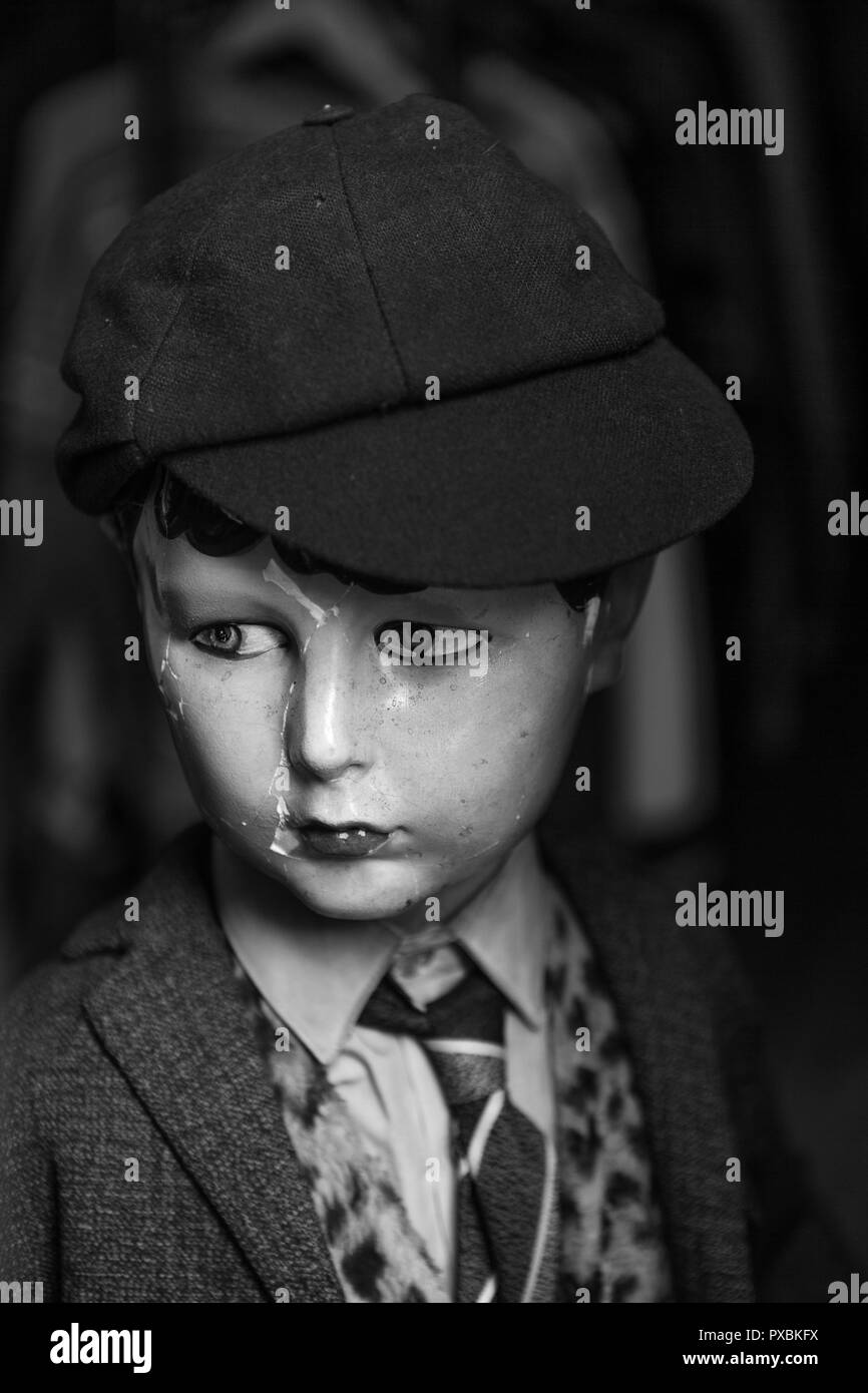 Un mannequin vintage d'un garçon en chemise et cravate et portant un chapeau de l'écolier. Banque D'Images