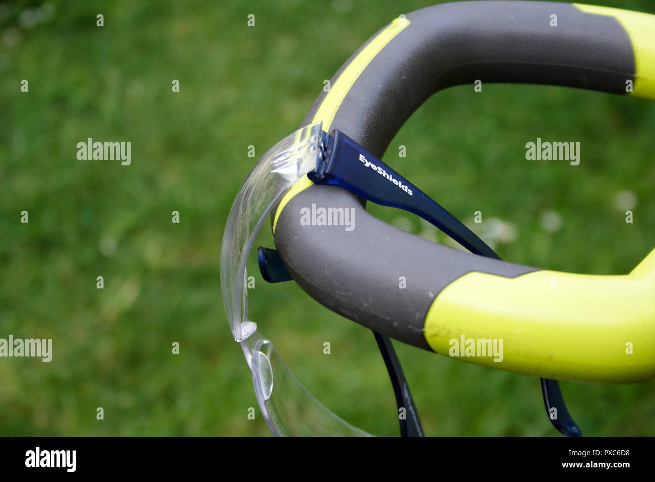 Protection des yeux Lunettes de sécurité accroché sur le guidon d'un coupe-herbe électrique Banque D'Images