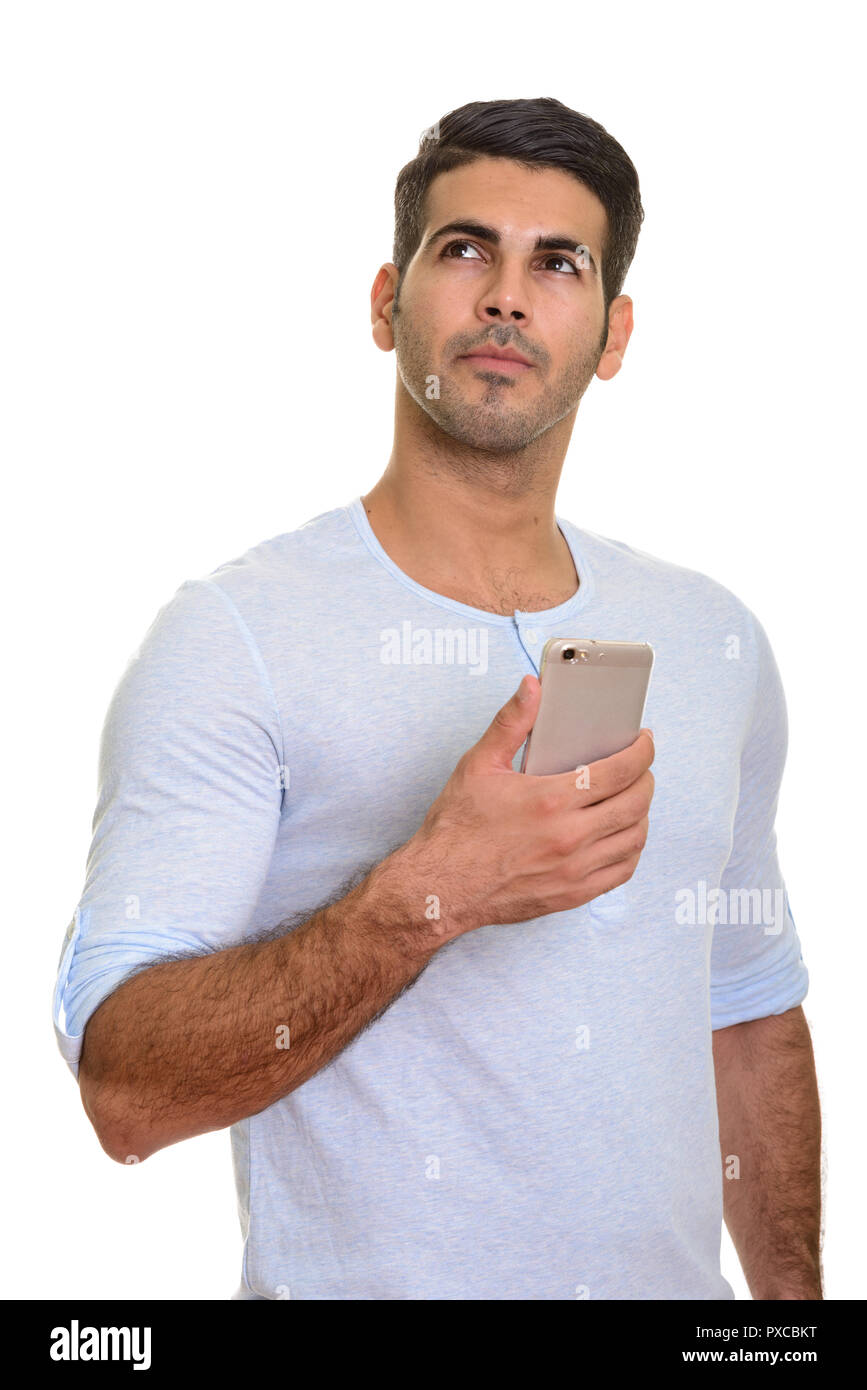 Beau jeune homme persan holding mobile phone en pensant Banque D'Images