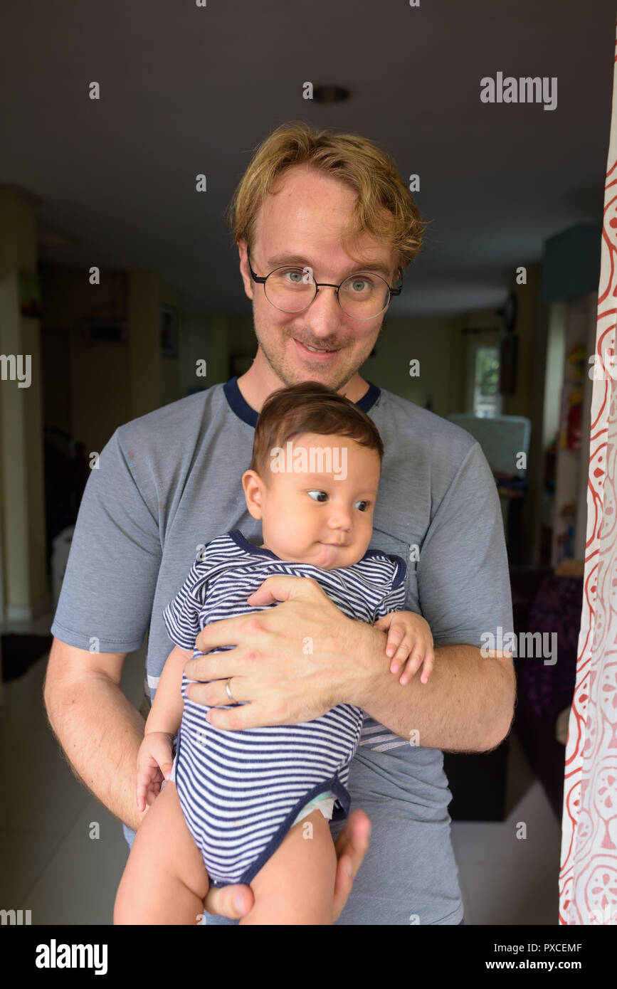 Père et fils liens affectifs au bébé à l'intérieur d'accueil Banque D'Images