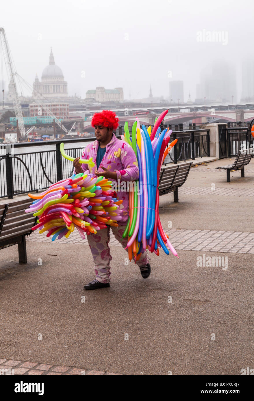 Un homme habillé de couleurs vives des ballons jouets vente sur la rive sud,Londres,Angleterre,UK Banque D'Images
