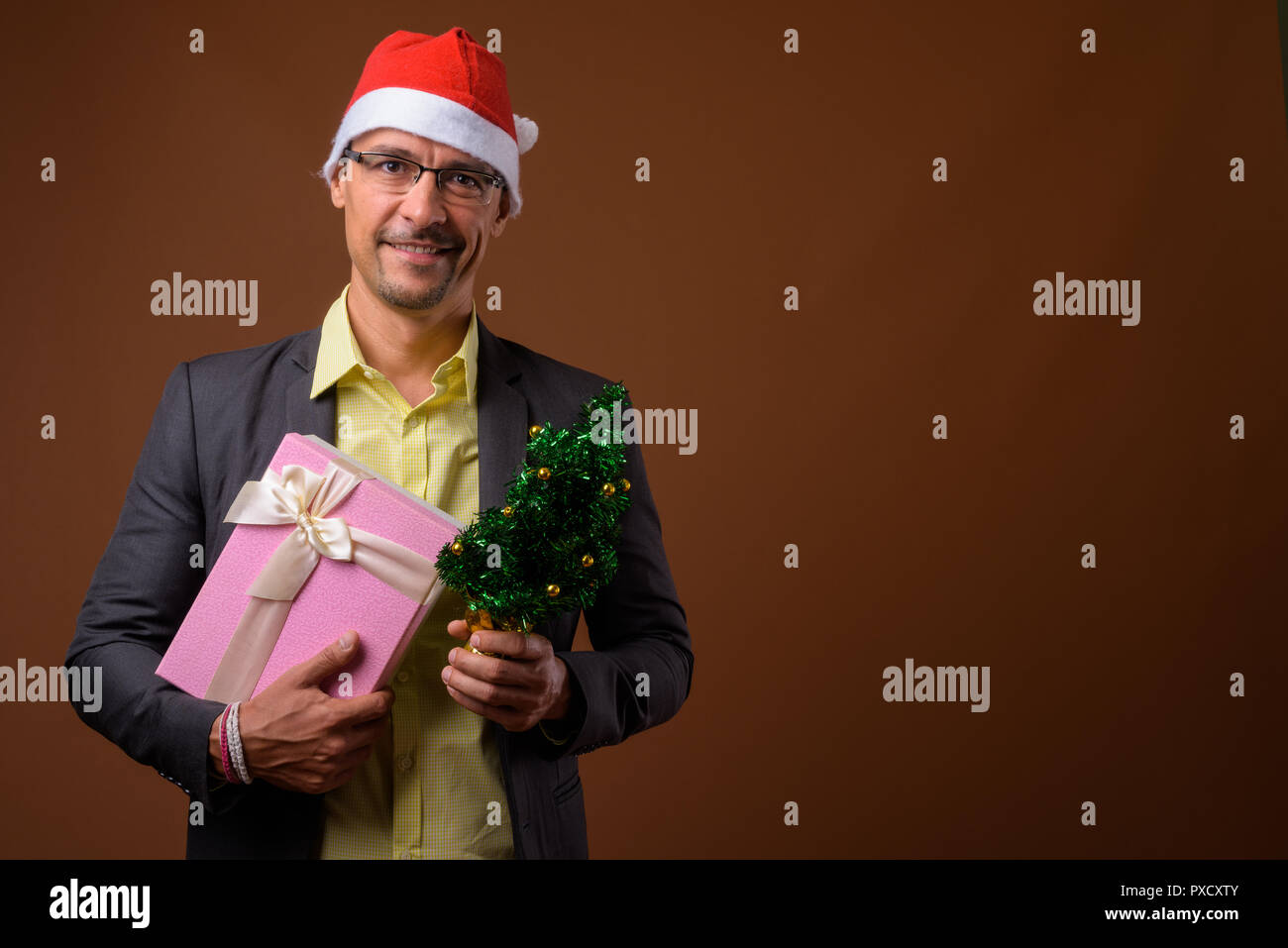 Portrait of handsome businessman prêt pour Noël contre fond brun Banque D'Images
