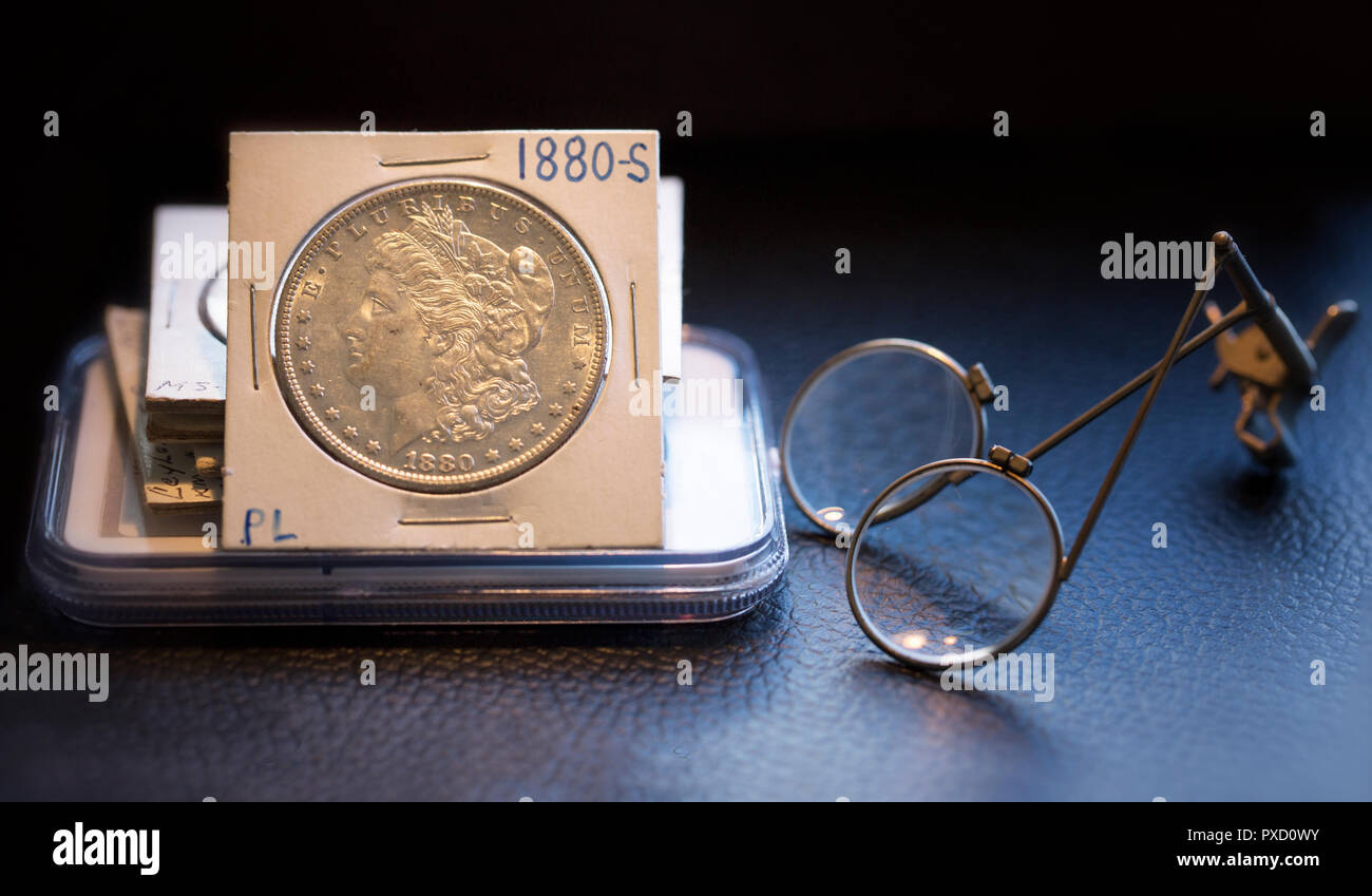 Collecteur de Pièce bureau avec une pile de pièces d'un beau Morgan Dollar état de menthe et la loupe en verre. Banque D'Images