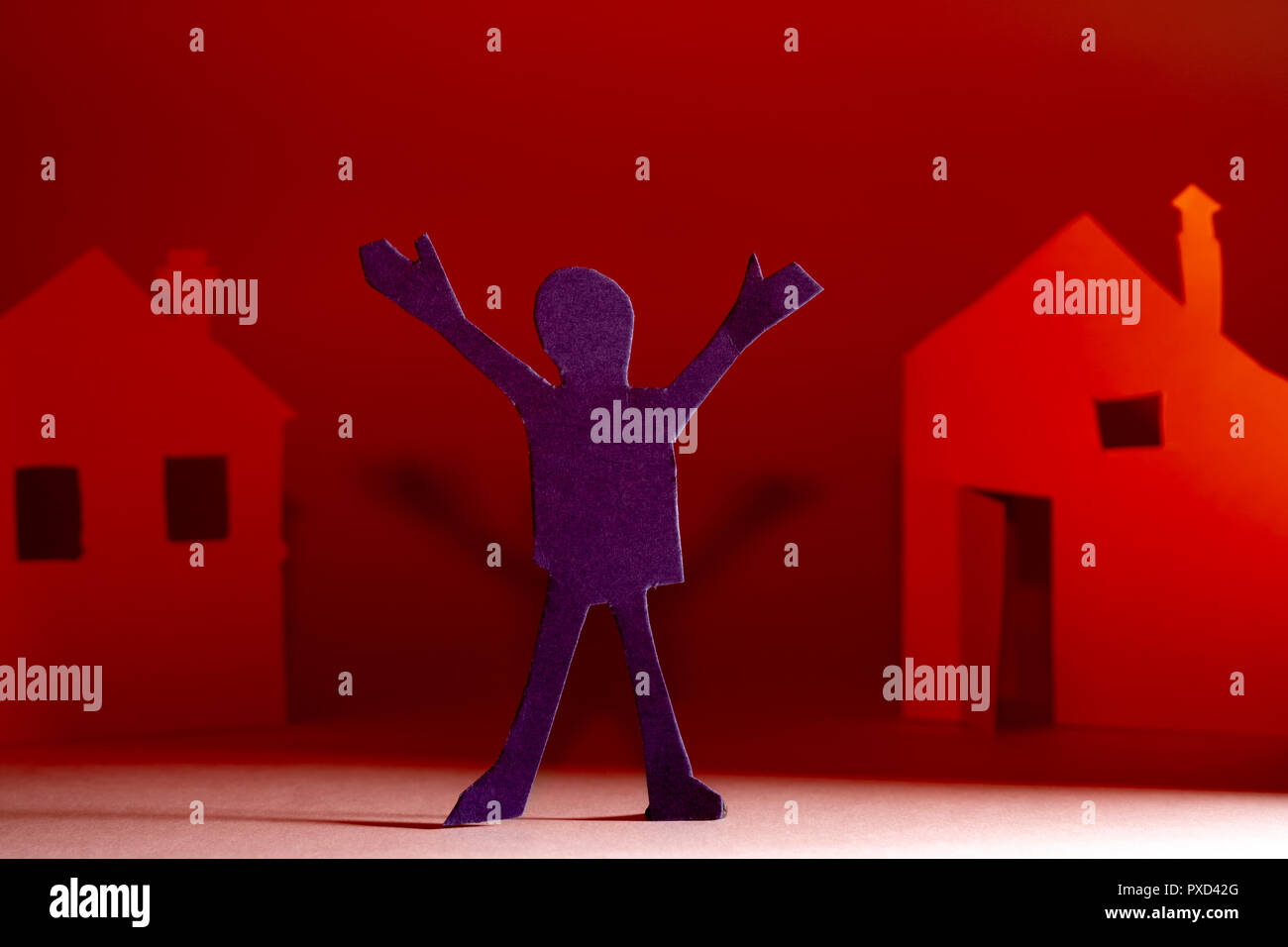 Papier coupé d'une personne sur l'arrière-plan des maisons. Banque D'Images