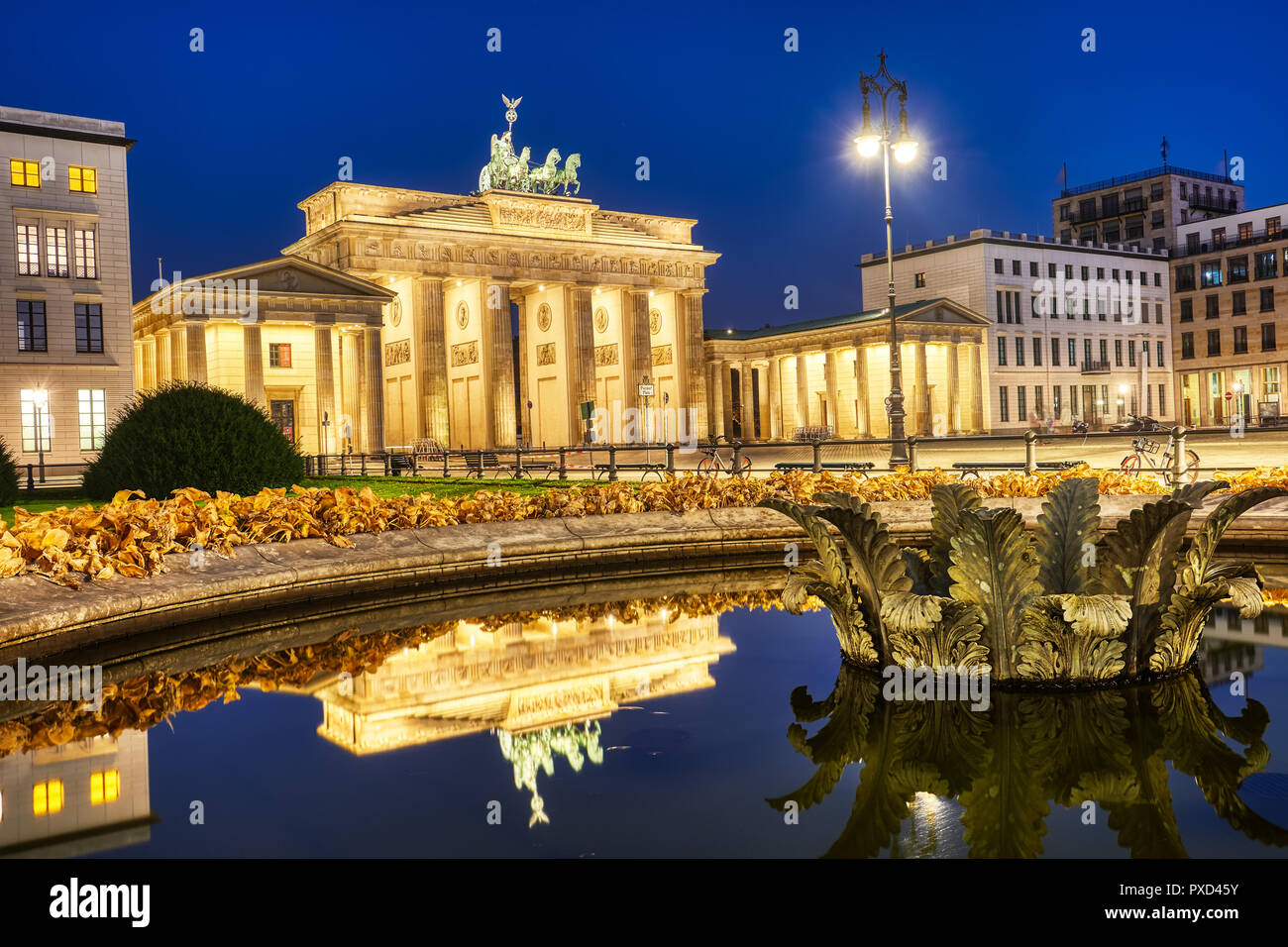 La célèbre porte de Brandebourg à Berlin la nuit, reflétée dans une fontaine Banque D'Images