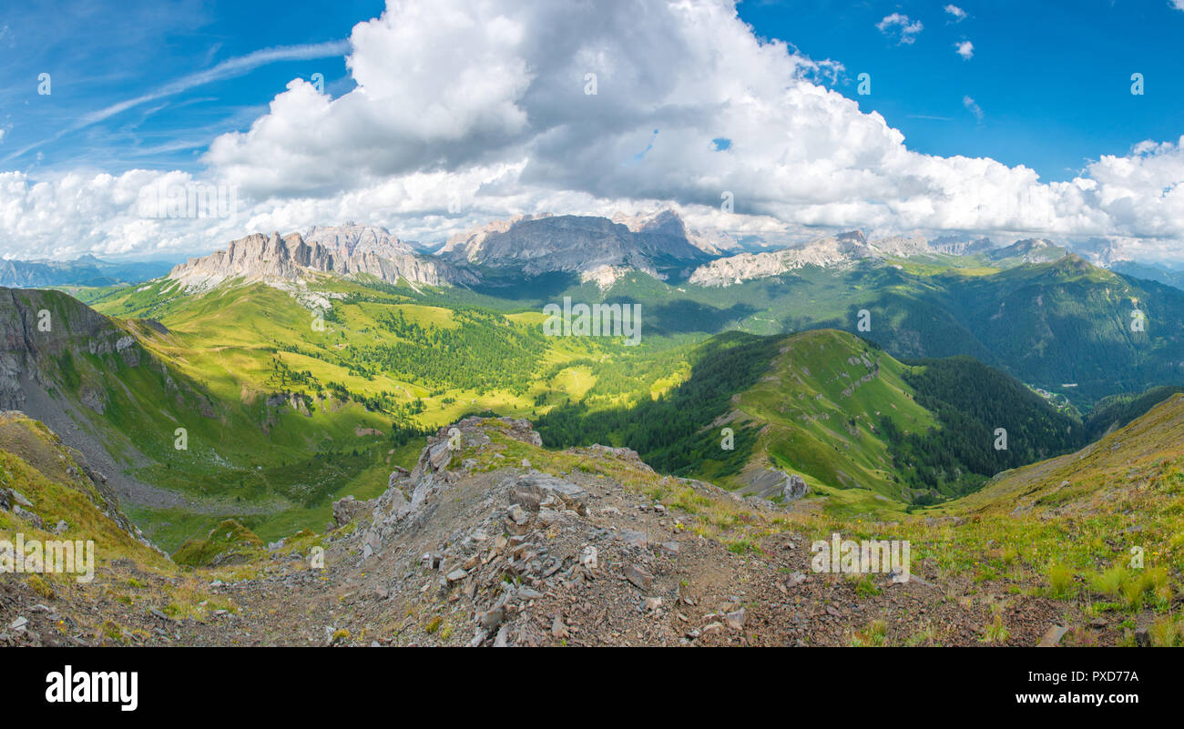 Vue panoramique sur les Dolomites, par un beau jour d'été. Approche de l'orage avec des nuages blancs, montagnes, vallée boisée et prairies herbeuses. Banque D'Images