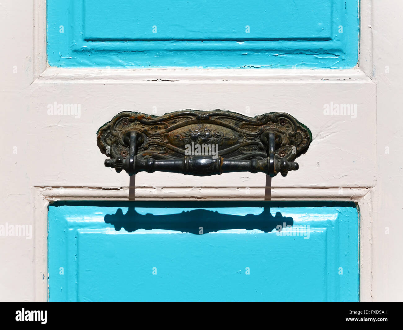 Poignée de porte en fer forgé ornemental sur une porte blanc-bleu Banque D'Images