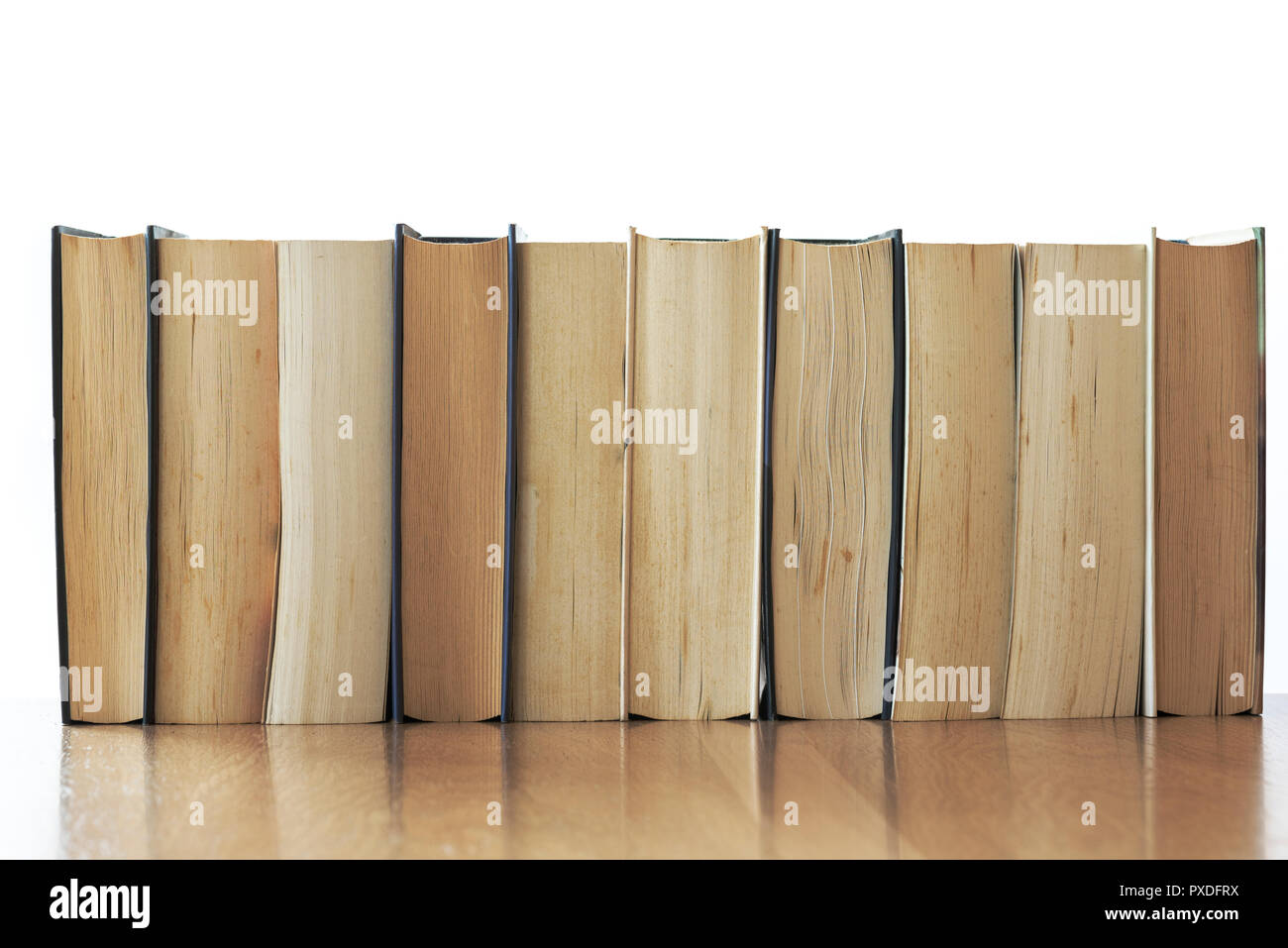 Rangée de vieux livres avec plateau en bois isolé. Banque D'Images