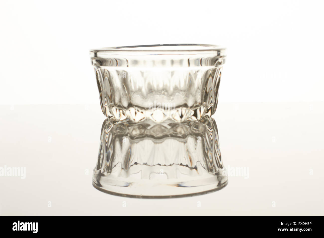 Verre transparent, petite tasse, sur fond blanc. Banque D'Images