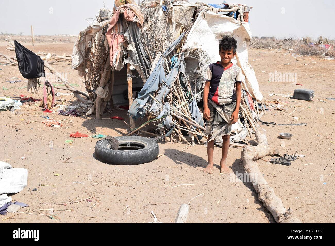 D'Aden, au Yémen. 21 Oct, 2018. Un garçon déplacées se trouve à côté de la hutte de sa famille à la périphérie d'Aden, Yémen, le 21 octobre 2018. Des milliers de déplacés de force les Yéménites ont commencé à se préparer pour l'hiver dans des huttes et des tentes au milieu des conditions de vie difficiles ainsi que le manque d'assistance humanitaire dans le pays arabe. Credit : Murad Abdu/Xinhua/Alamy Live News Banque D'Images