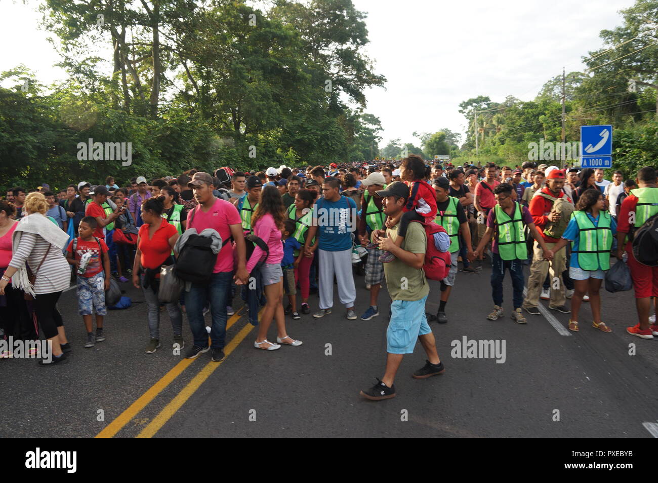 Ciudad Hidalgo, au Mexique. 21 Oct, 2018. Différentes personnes en gilet vert mener la marche de l'Amérique centrale la position des États-Unis. Des milliers d'Honduriens, sont rejoints par les migrants salvadoriens et guatémaltèques dans le sud du Mexique. La caravane avec les sacs et les enfants sur leurs épaules à pied vers les États-Unis dans l'espoir d'un avenir meilleur. Credit : Rafael Angel/dpa/Alamy Live News Banque D'Images