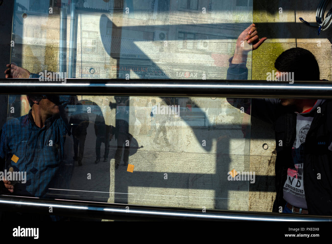 La Turquie. Istanbul. Deux ouvriers vitriers changer le verre dans la rue. Banque D'Images