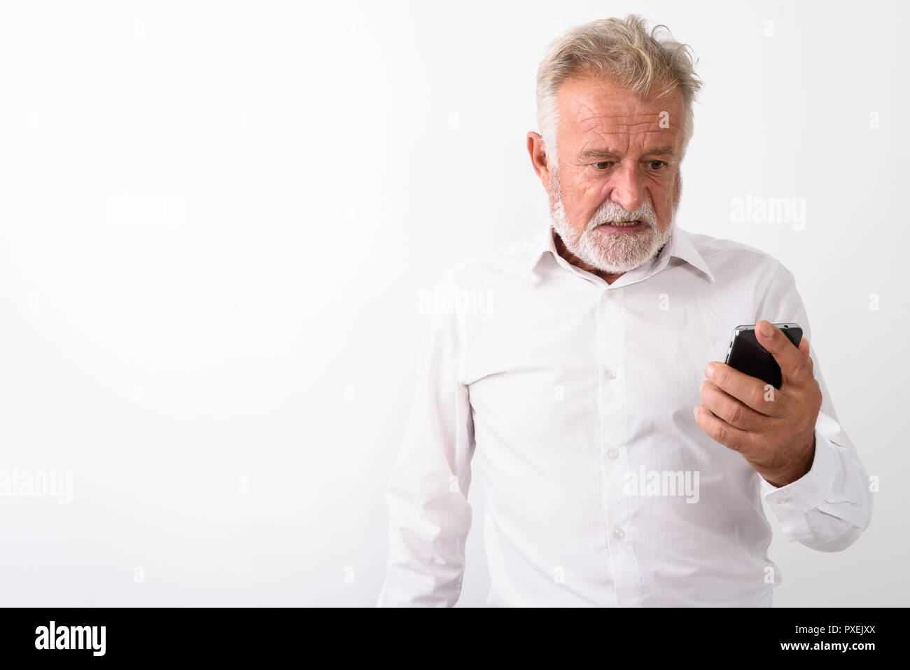 Portrait d'homme barbu senior en colère à l'aide de mobile phone Banque D'Images