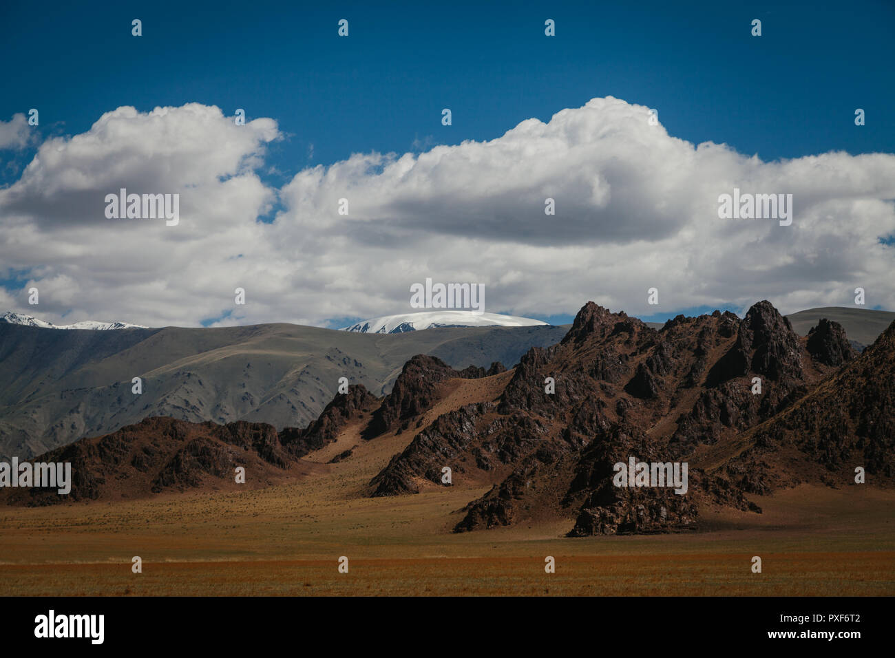 Paysage de Mongolie robuste et de formations rocheuses. Les nuages et ciel bleu avec la montagne Tsambagarav dans la distance. Khovd, Mongolie Banque D'Images