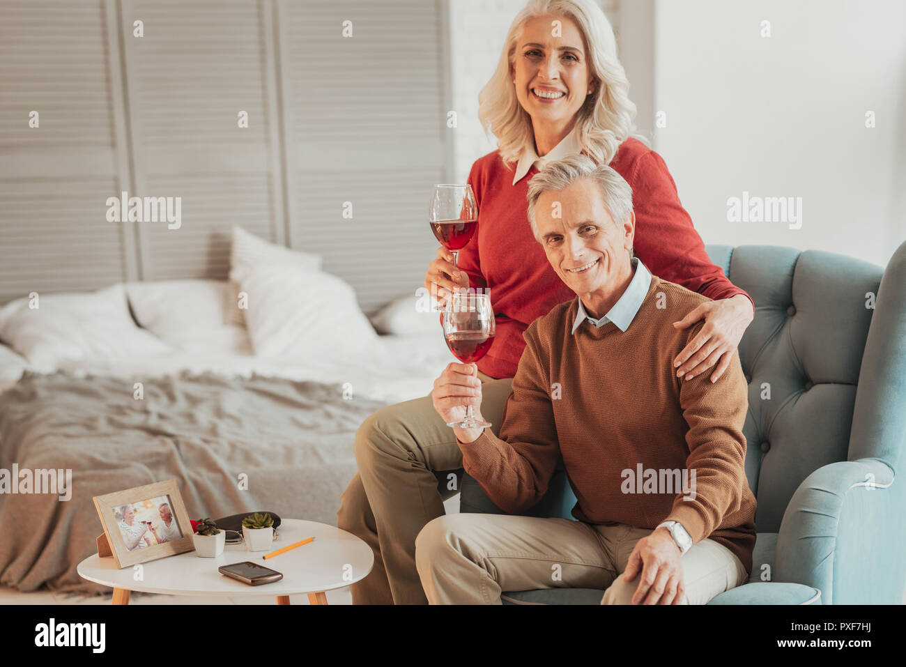 Heureux Senior couple sitting on chair and looking at camera Banque D'Images