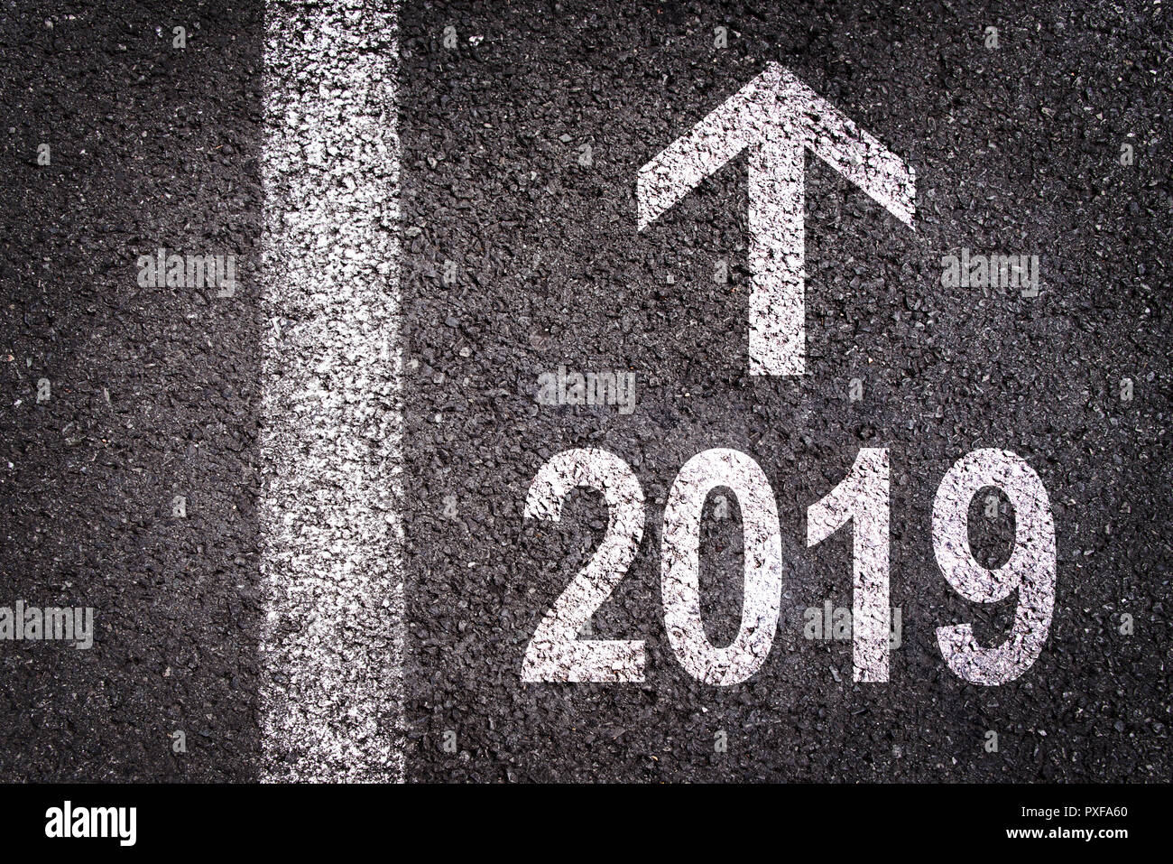 2019 et une flèche écrit sur une route asphaltée background Banque D'Images