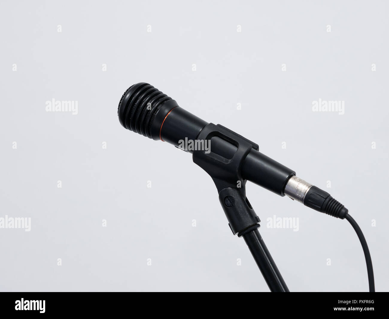 Microphone noir câblé sur stand à fond blanc Banque D'Images