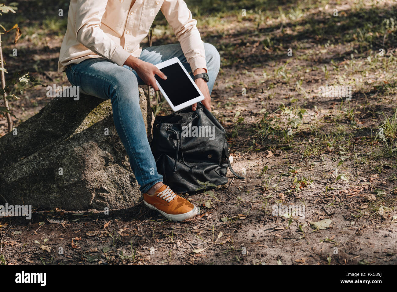 Vue partielle de l'homme avec sac à dos et digital tablet in park Banque D'Images