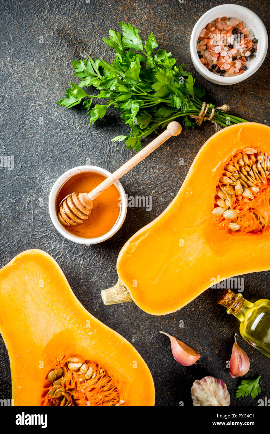 Matières premières moitiés de citrouille ou courge musquée, avec de l'huile d'olive, épices et ingrédients pour la cuisson sur fond de marbre blanc.Haut de la copie de la vue de l'espace. Banque D'Images