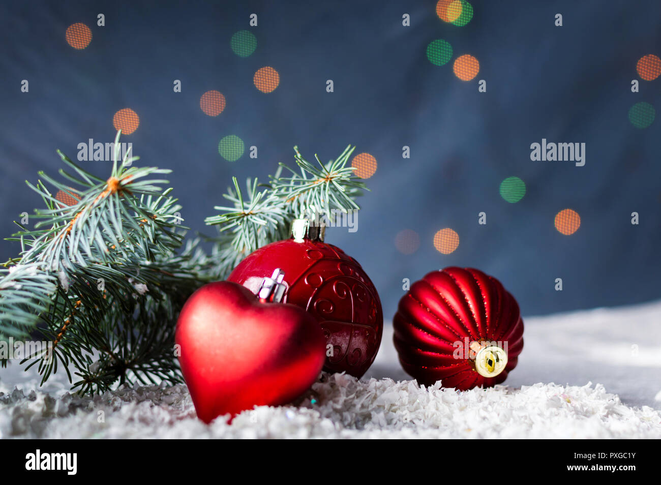 Les boules de Noël rouges et de branches de sapin avec arrière-plan de fête Banque D'Images