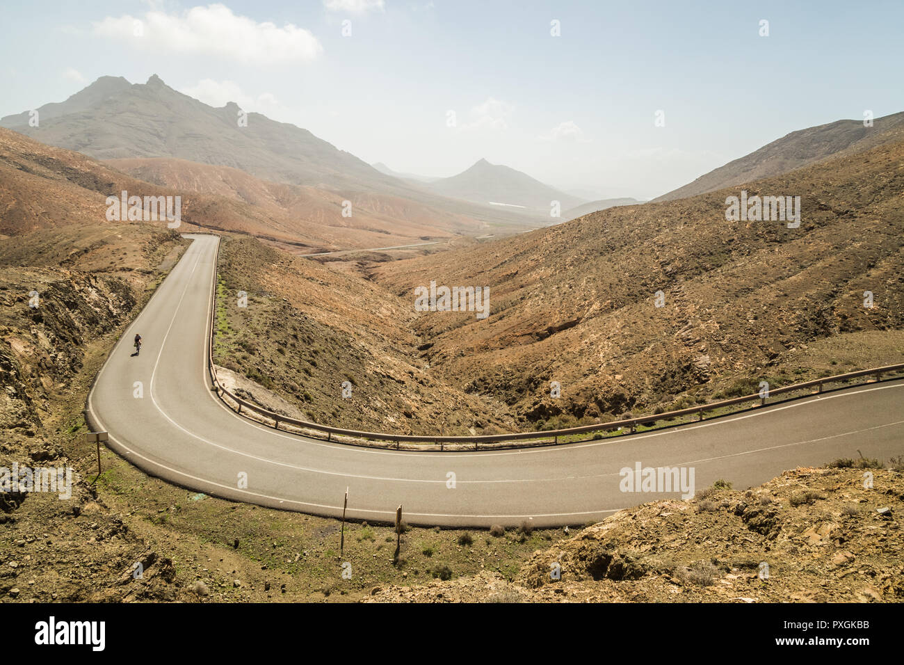 Vue panoramique sur route sinueuse avec les cyclistes au point de vue astronomique, 339 de Fuerteventura, Espagne. Banque D'Images