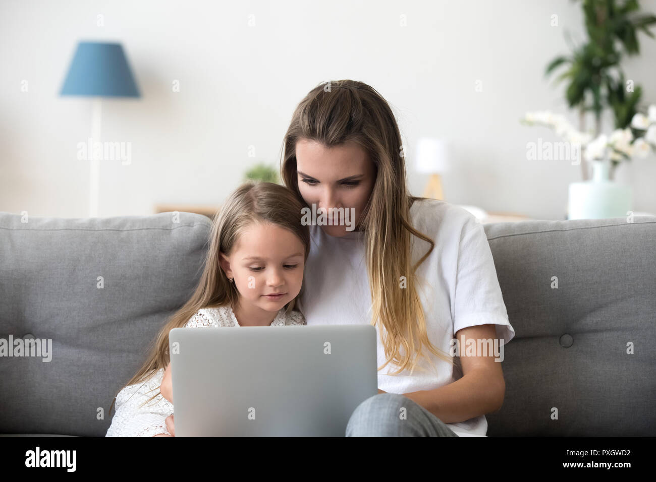 Mère et fille se détendre sur la table à l'aide d'ordinateur portable Banque D'Images