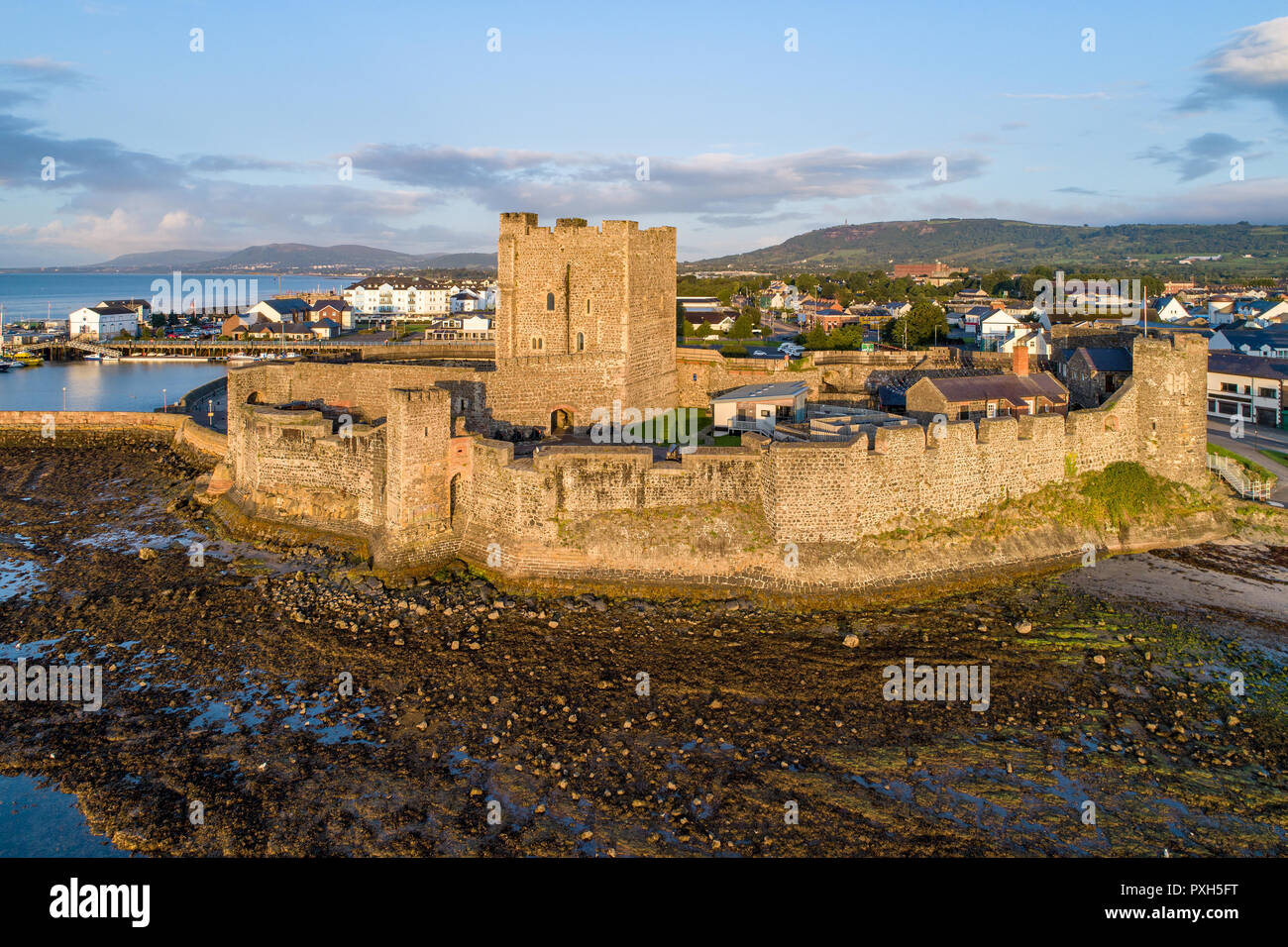 Cité médiévale du château normand à Carrickfergus près de Belfast dans le lever du soleil la lumière. Vue aérienne avec marina, les sédiments et la ville de Belfast Lough Banque D'Images