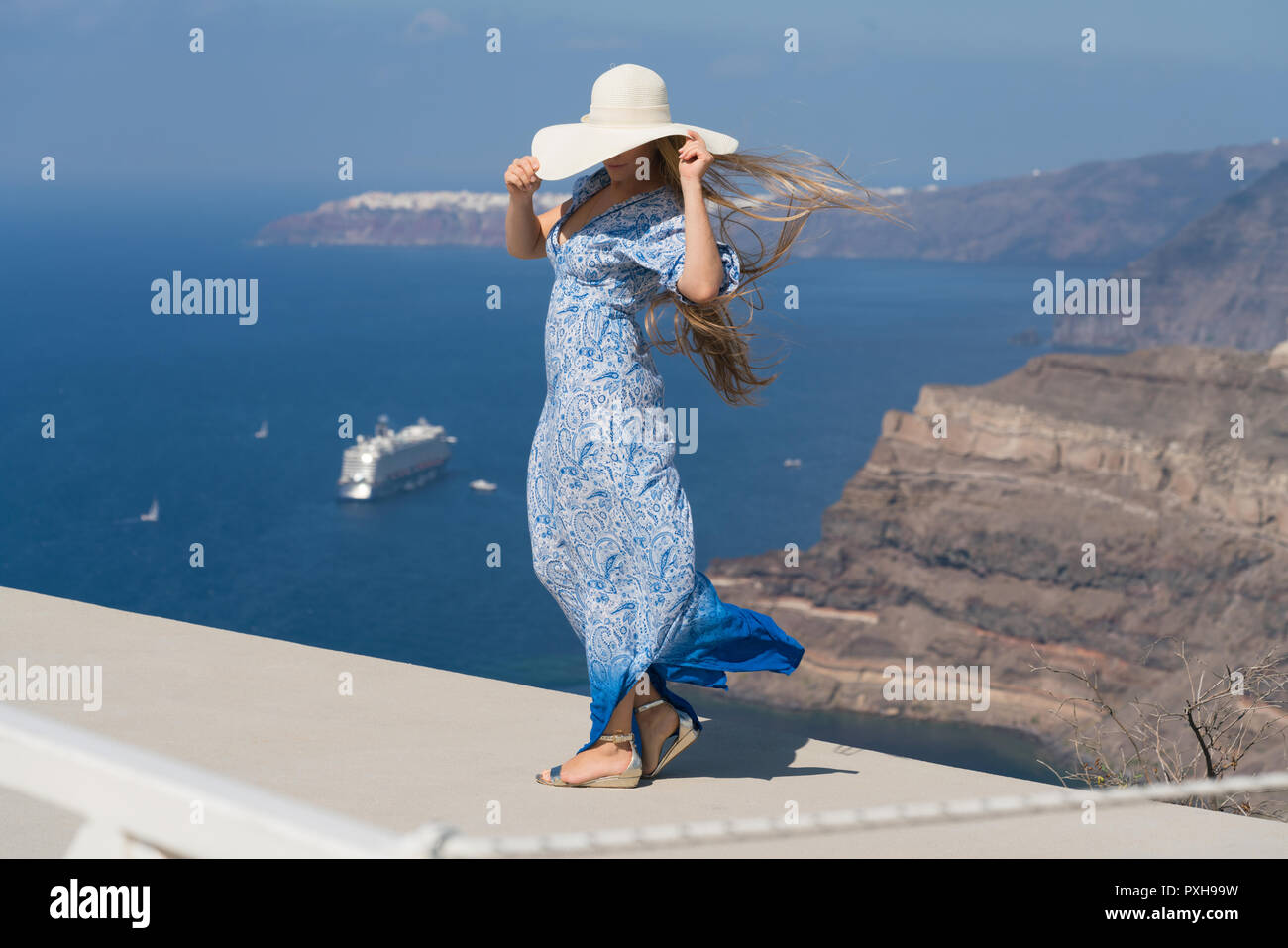 Jeune femme dans une robe bleu et blanc bénéficie d'une promenade autour de Santorini Banque D'Images