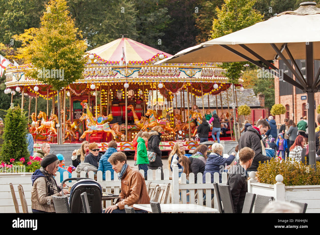 Les personnes bénéficiant du soleil d'automne à l'extérieur du café à côté de l'carousal rond-point à la propriété du National Trust de Tatton Park à Knutsford Cheshire UK Banque D'Images