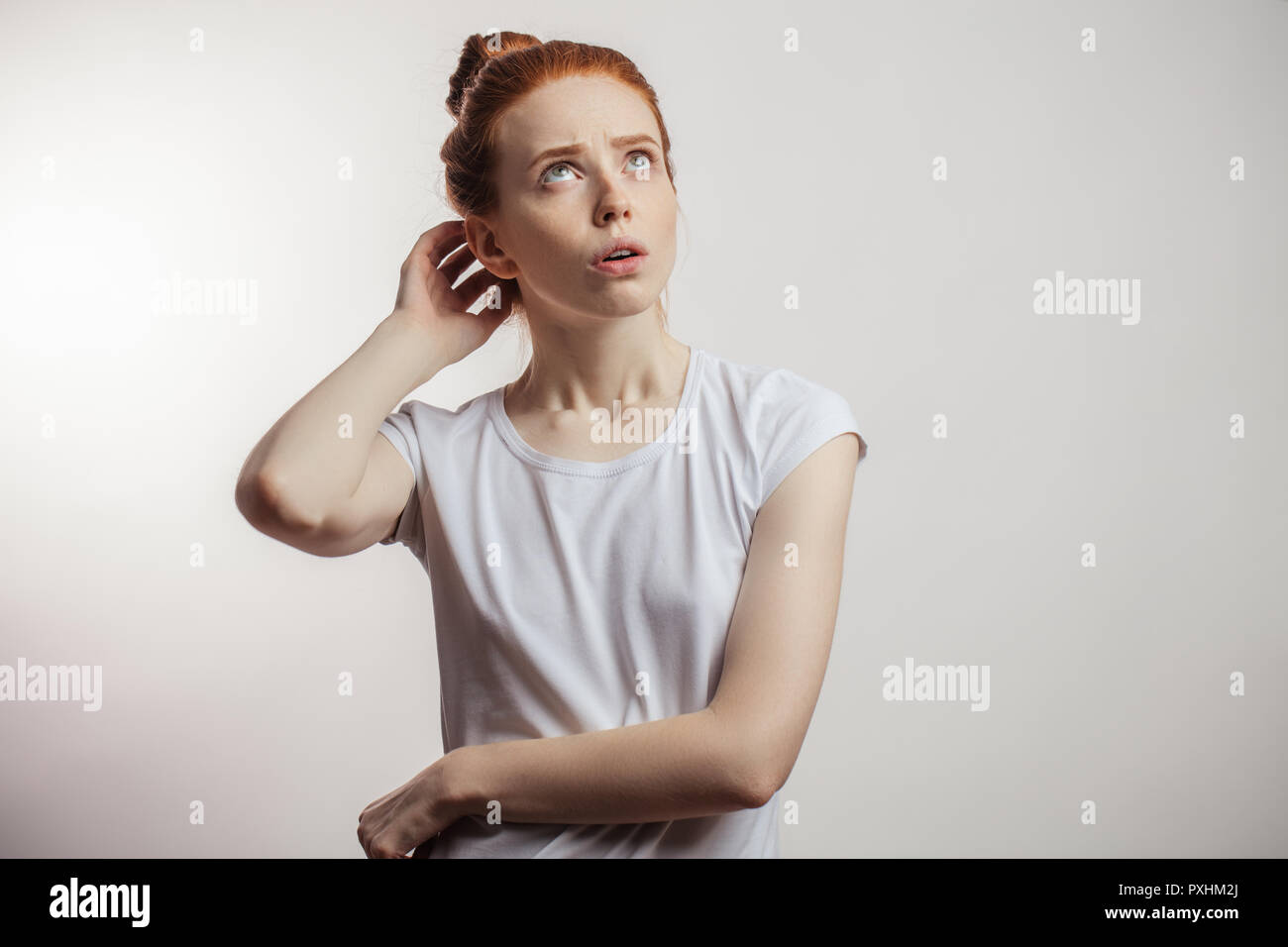 Redhaired woman with pensive expression isolé sur fond blanc. Banque D'Images