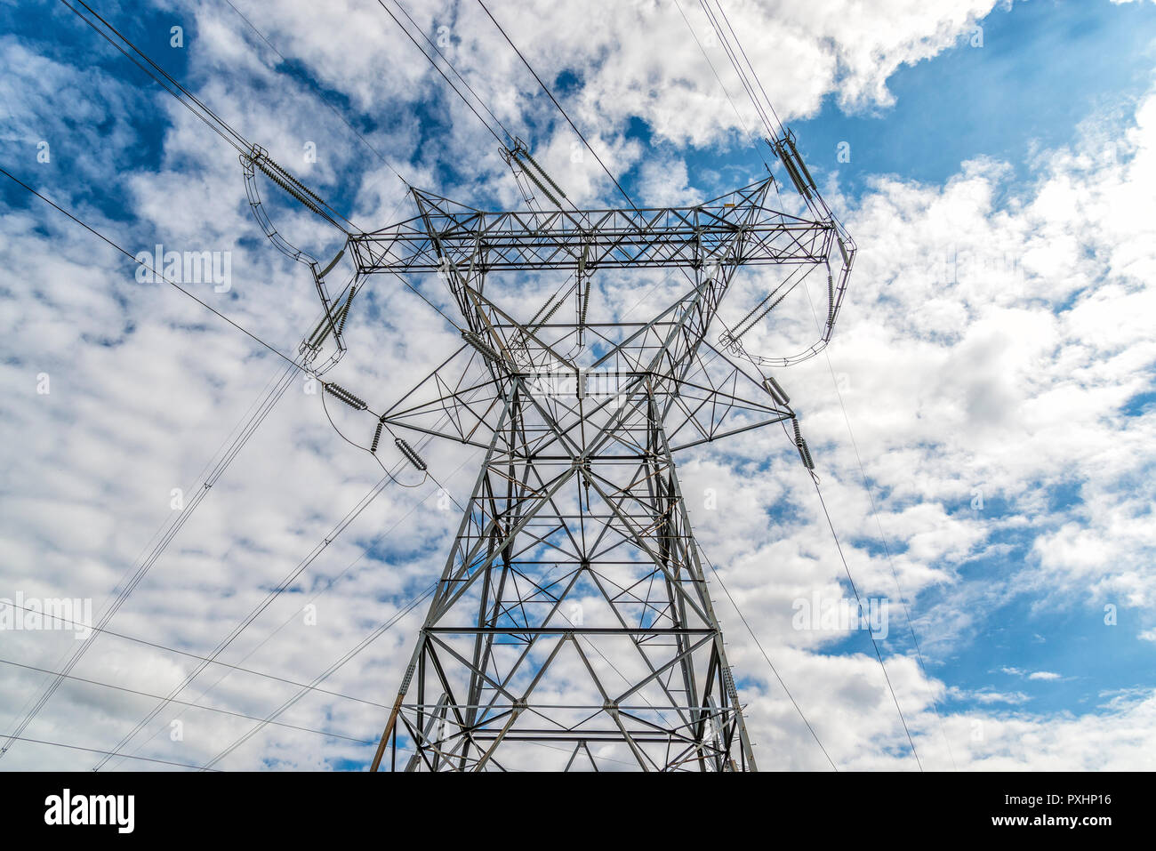 D'un coup horizontal tour haute tension et les lignes électriques sous ciel nuageux. Banque D'Images