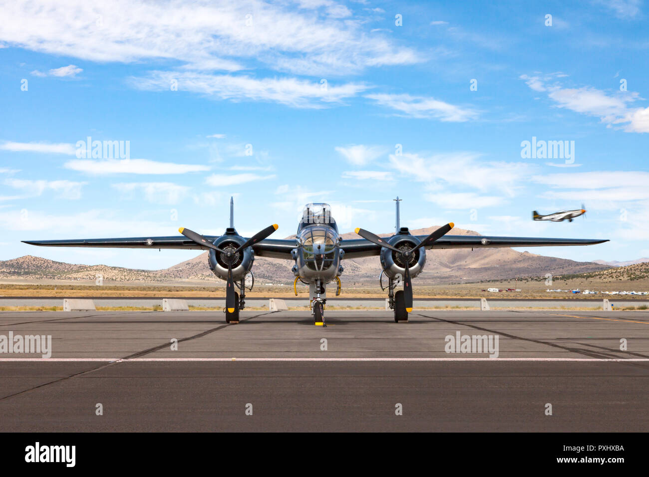 North American B-25 Mitchell bomber moyen sur la rampe à Reno-Stead Airport de Nevada tandis qu'un P-51 Mustang obtient de la piste aérienne derrière Banque D'Images