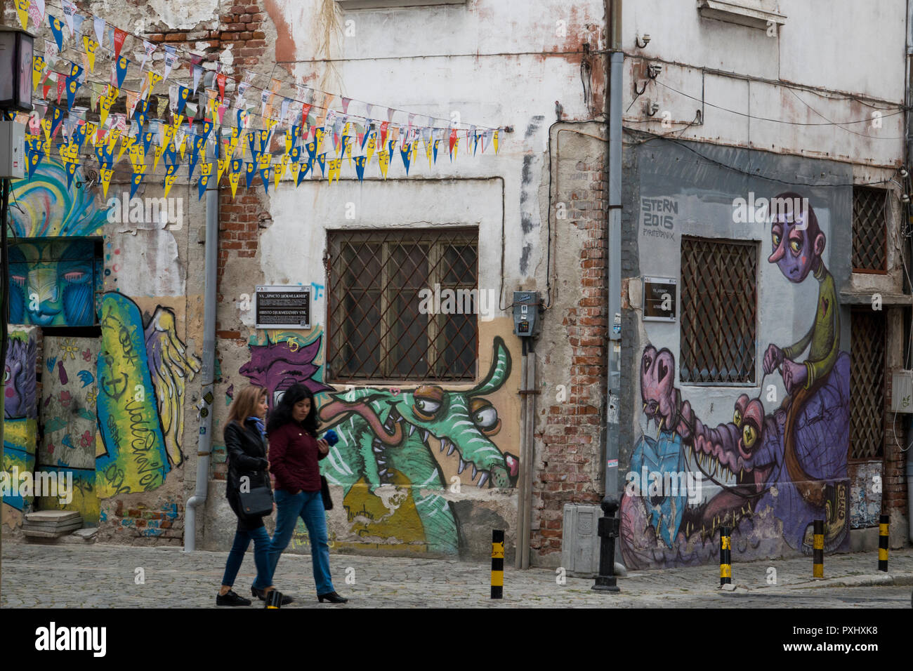 Les femmes passent devant le street art graffiti, dans la vieille ville de Plovdiv, Bulgarie Banque D'Images