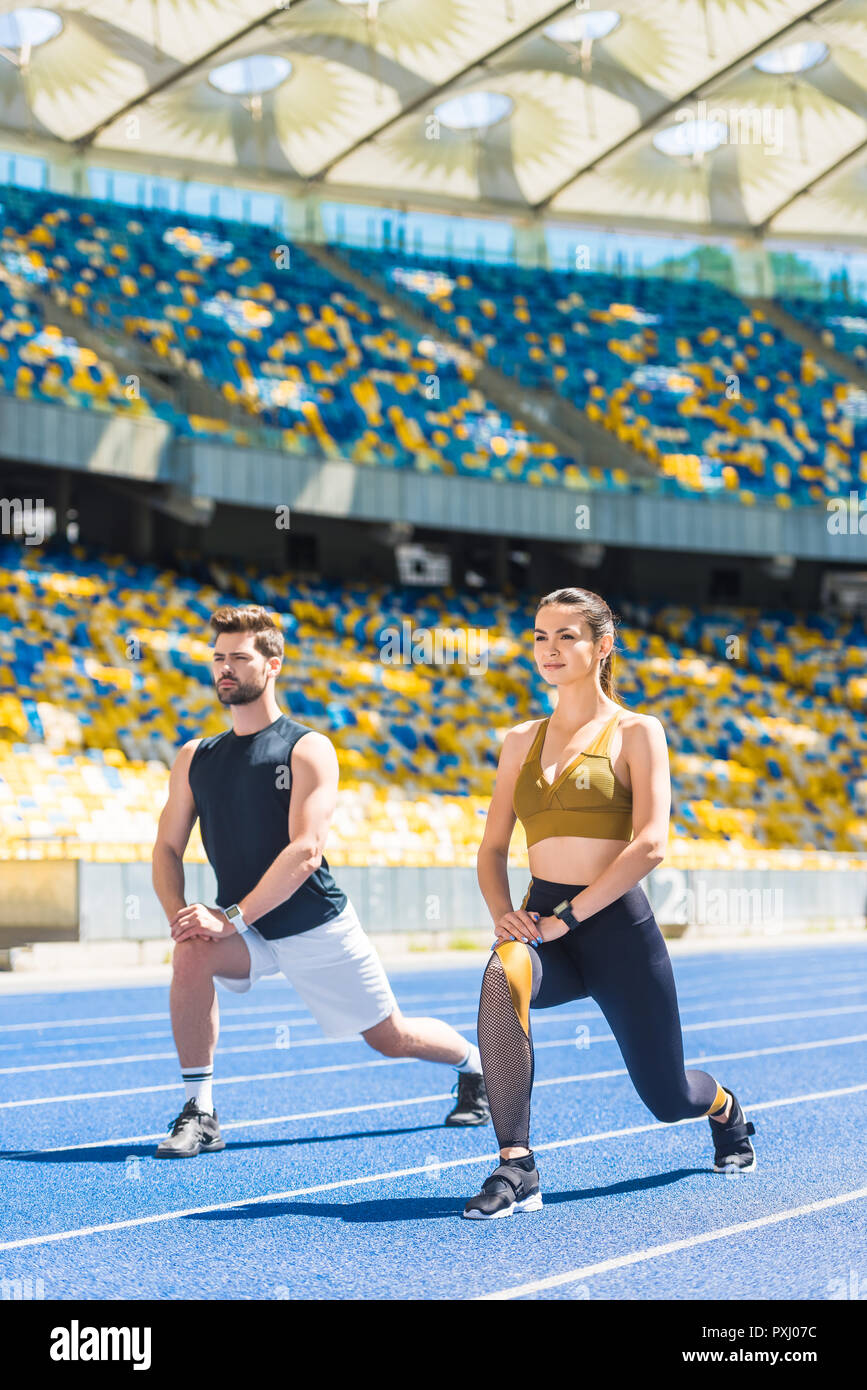 Jeune couple d'athlétisme l'échauffement avant l'entraînement sur une piste de course au stade de sport Banque D'Images